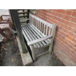 Weathered teak garden bench with slatted back and seat