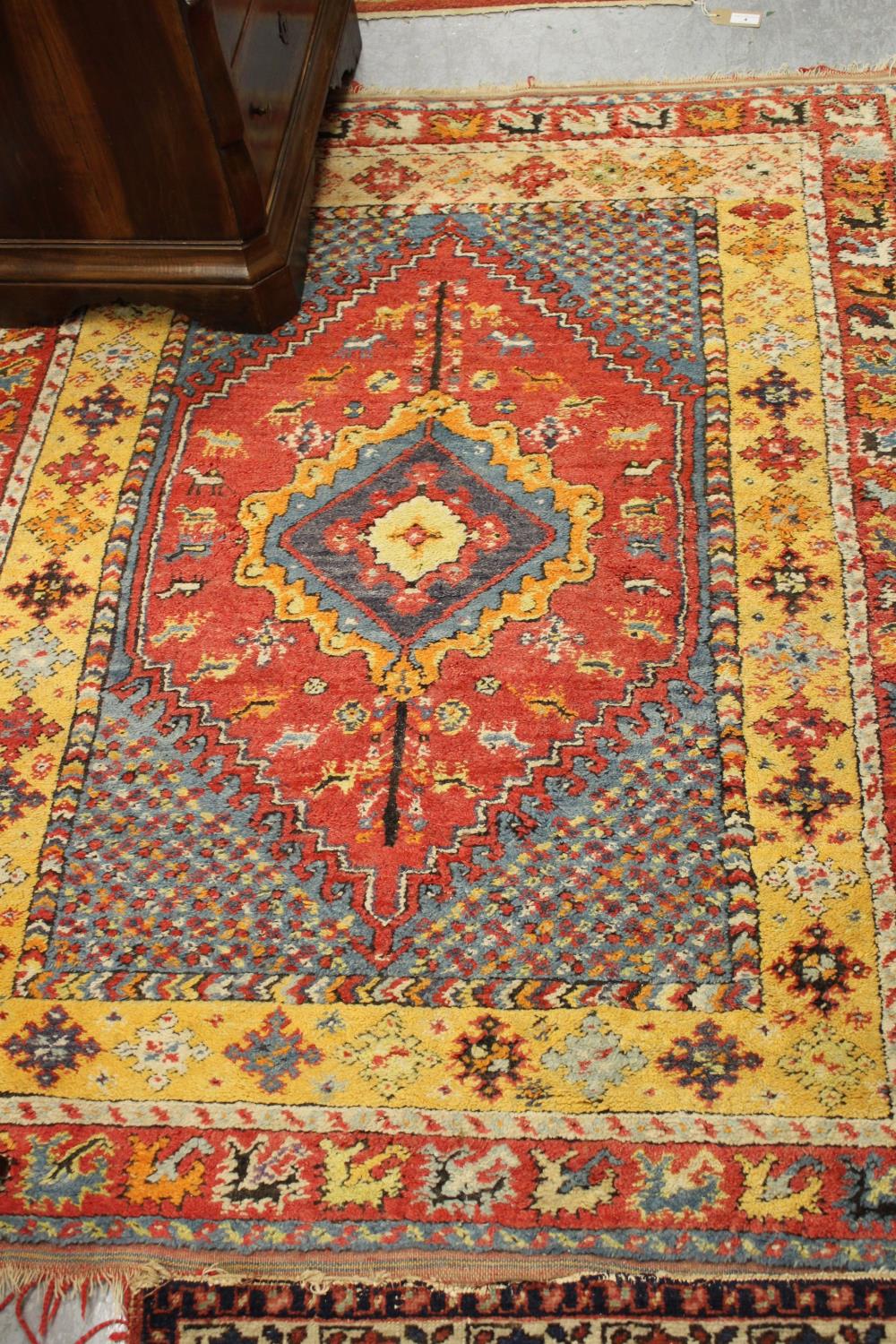 Small Turkish rug with a medallion design in shades of pale blue, pink and orange