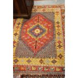 Small Turkish rug with a medallion design in shades of pale blue, pink and orange