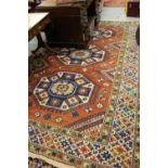 20th Century Turkish carpet of Kazak design with a triple hooked medallion pattern on a terracotta