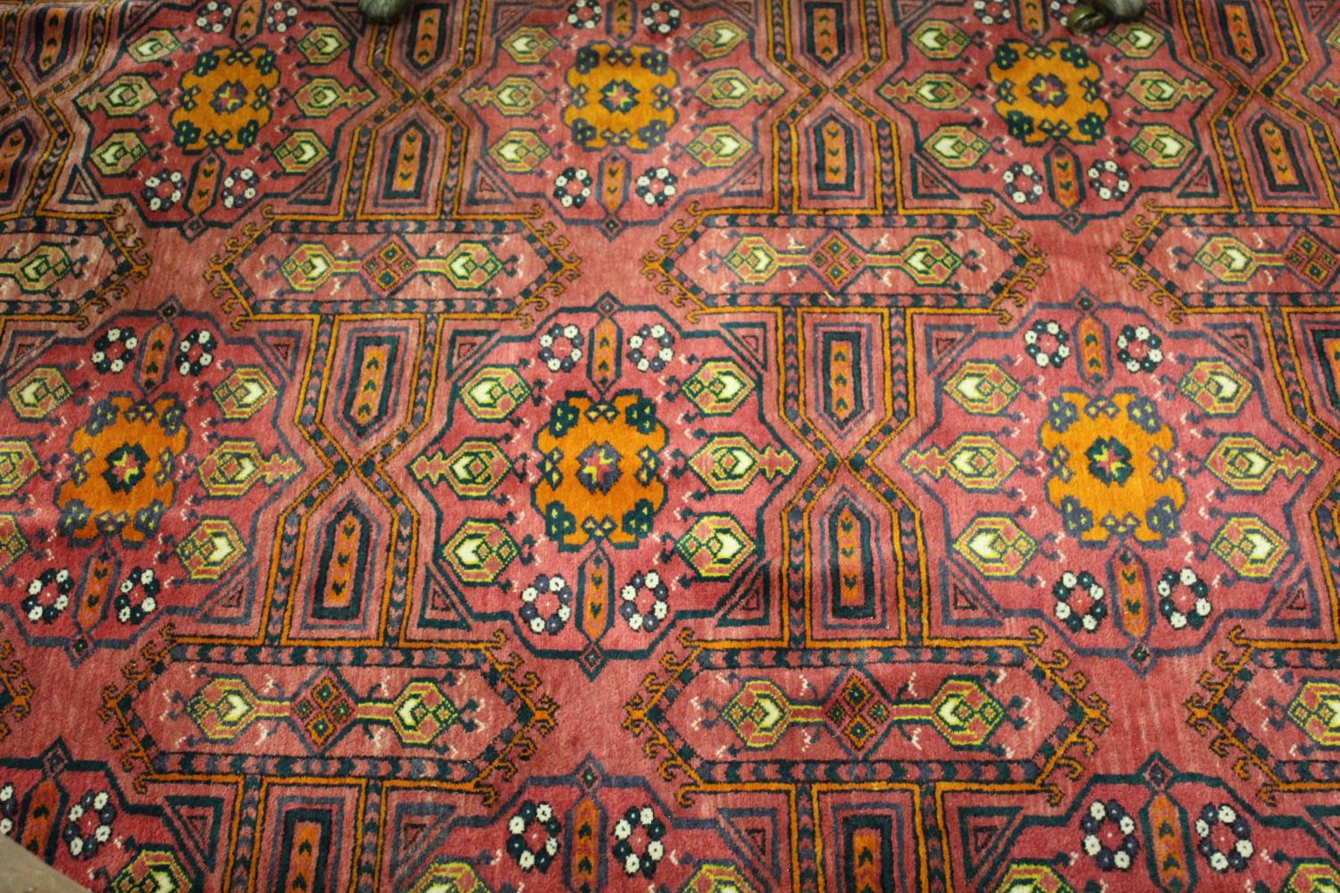 Afghan carpet with three rows of six gols on a wine ground with borders, 11ft x 7ft approximately