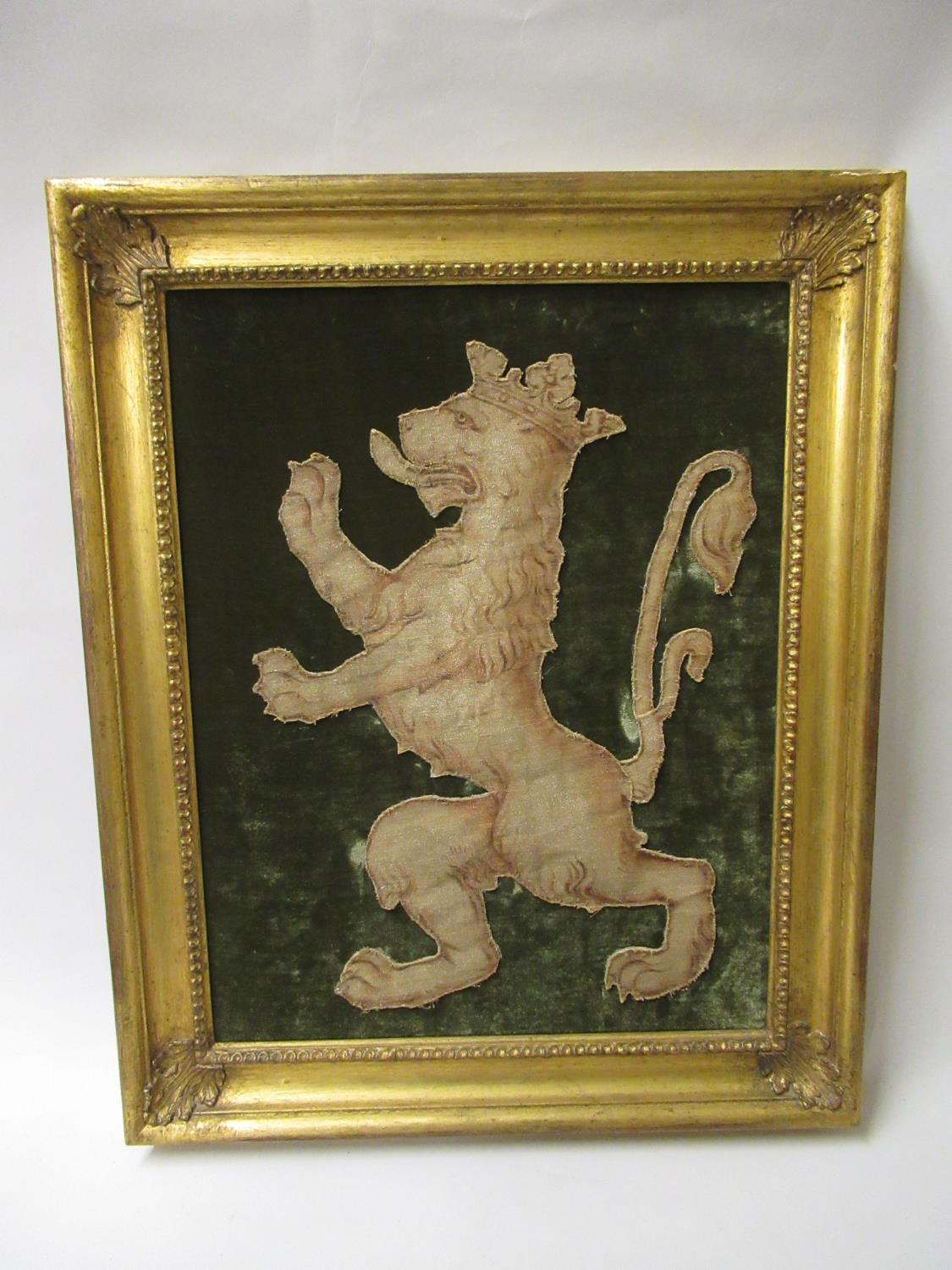 Antique cut-out textile fragment of a lion rampant mounted on a velvet backing, 19ins x 14ins