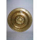 Antique brass alms dish with repousse decorated domed centre panel, 16.75ins diameter In our opinion