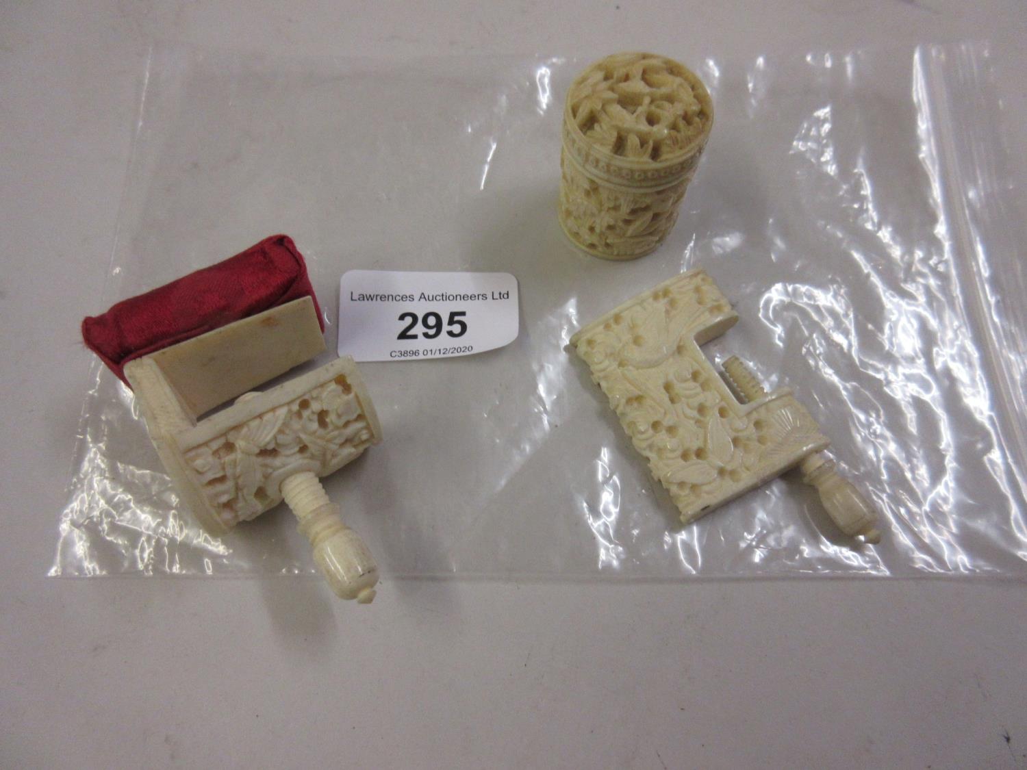 Two 19th Century Chinese carved ivory sewing clamps, together with a similar small cylindrical box