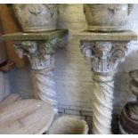 Pair of painted weathered cast concrete columns with mask head and Corinthian pilasters above spiral