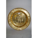 Antique brass alms dish, the centre panel with repousse scene of Adam and Eve picking the