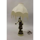 Painted composition table lamp in the form of a girl flower seller, 24ins high excluding shade