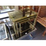 Nest of three Maison Jansen style brass and smoked glass inset tables