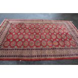 Pakistan Bokhara design carpet having four rows of twelve gols with multiple borders on a wine