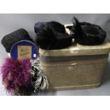 Small rectangular trunk containing a collection of various fur and feather hats, two ostrich feather