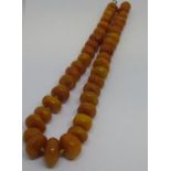 Butterscotch amber bead necklace of irregular squat form, 62cms long, 142g See pics