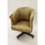 Early 20th Century tan leather upholstered swivel office chair on a crossover base with casters