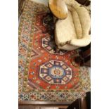 20th Century Turkish carpet of Kazak design with a triple hooked medallion pattern on a terracotta
