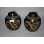 Pair of 20th Century cloisonne ginger jars decorated with yellow dragons on a black ground, 7ins