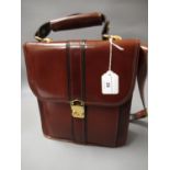 Brown leather bag with black trim, gold tone hardware, shoulder strap and carrying handle