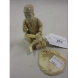 Small 19th Century Japanese carved ivory figure of a seated tradesman, red seal mark to base (at