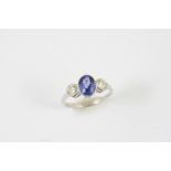 A SAPPHIRE AND DIAMOND THREE STONE RING the oval-shaped sapphire is set with two circular-cut