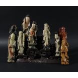 CHINESE SOAPSTONE GROUP OF IMMORTALS, in different colour stones on a stepped, scrolling soapstone