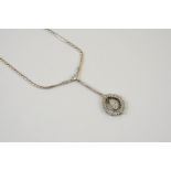 A DIAMOND NECKLACE formed with a pear-shaped diamond drop set within a surround of baguette and