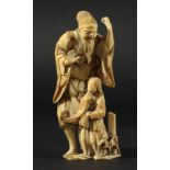 JAPANESE IVORY OKIMONO, Meiji, of a bearded man standing above a long haired girl, height 11cm
