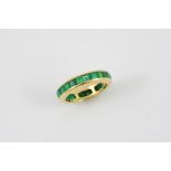 AN EMERALD FULL CIRCLE ETERNITY RING mounted with calibre-cut emeralds in 18ct yellow gold. Size L