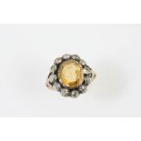 A DIAMOND AND CITRINE CLUSTER RING the oval-shaped citrine is set within a surround of old