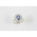 A SAPPHIRE AND DIAMOND CLUSTER RING the oval-shaped sapphire is set within a surround of ten