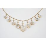 A MOONSTONE AND GOLD NECKLACE mounted with graduated oval and circular shaped moonstone drops,