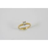 A DIAMOND SOLITAIRE RING set with an emerald-cut diamond, in 18ct gold. Size J.