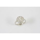 A DIAMOND CLUSTER RING the circular-cut diamond is set within a surround of smaller circular-cut
