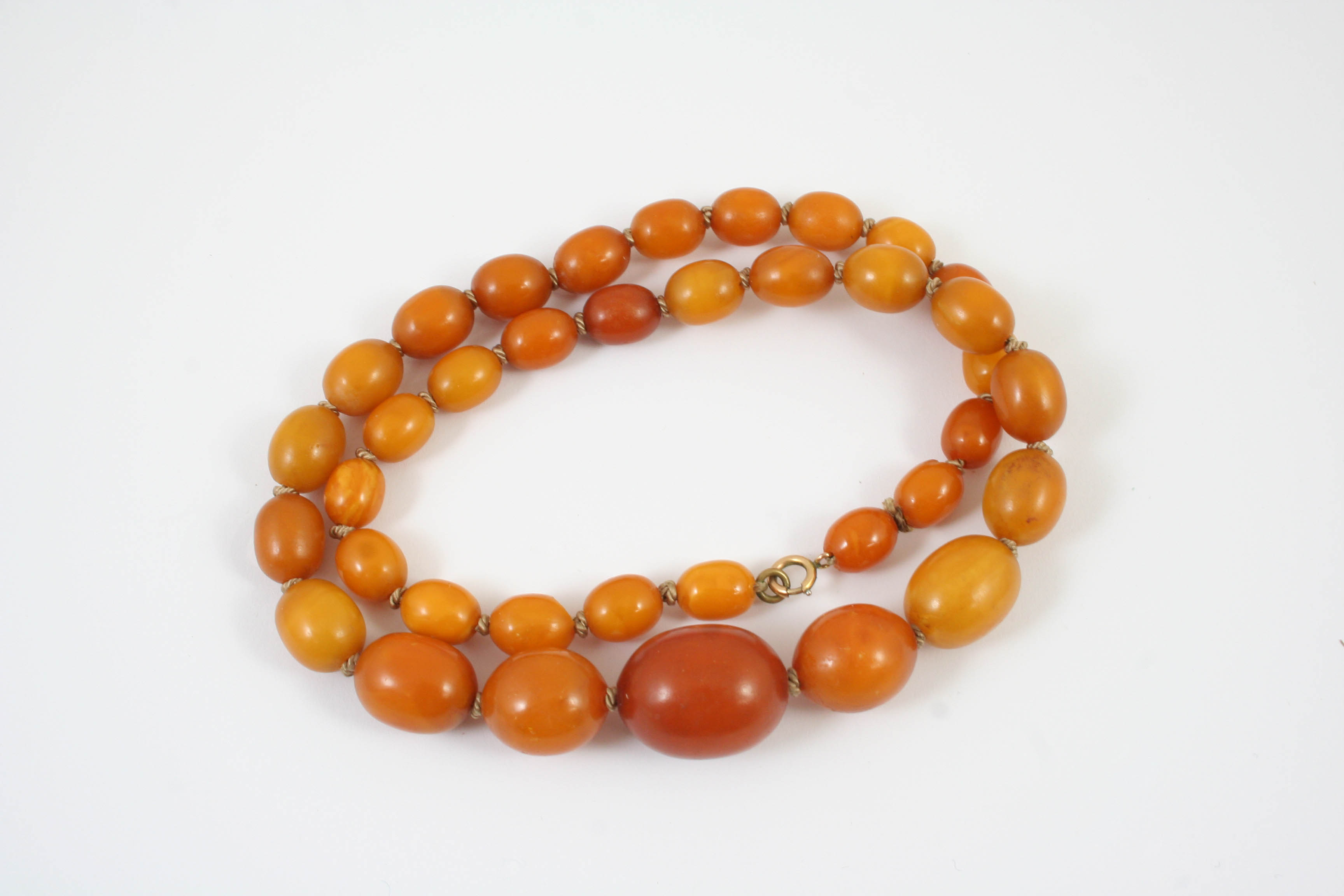 A SINGLE ROW GRADUATED AMBER BEAD NECKLACE 53cm long, 34 grams
