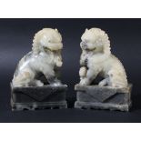 PAIR OF CHINESE SOAPSTONE GUARDIAN LIONS, in off white and grey, carved seated on rectangular