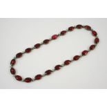 A PASTE SET NECKLACE formed with oval-shaped red paste stones and white circular paste stones in