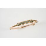 AN EDWARDIAN GOLD, TURQUOISE AND PEARL SET HALF HINGED BANGLE set to one side with ball and wirework