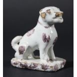DELFT FIGURE OF A DOG, probably Dutch, late 18th century, modelled seated, with manganese patches,