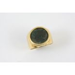 A GOLD RING mounted with a Roman coin, 11.6 grams. Size Q