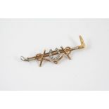 A DIAMOND AND GOLD HUNTING BROOCH formed with a diamond set horseshoe mounted on a gold riding crop,