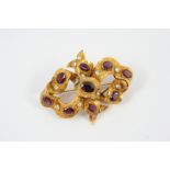 A VICTORIAN GOLD AND GARNET BROOCH the engraved bow mount is set with oval-shaped garnets, 7cm long,