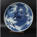 CHINESE BLUE AND WHITE CHARGER, Kangxi style but later, painted with a scrolling dragon amongst