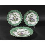 THREE WORCESTER PLATES, circa 1760-70, painted with exotic birds inside apple green borders with