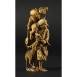 JAPANESE IVORY OKIMONO, Meiji, a man carrying a boy with a deer to his side, height 10.5cm