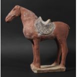 CHINESE TERRACOTTA HORSE, Tang Dynasty, standing four square with a saddle, with red and black