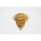 A VICTORIAN GOLD BROOCH the oval-shaped gold mount with embossed decoration and centred with a green