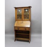 ARTS & CRAFTS OAK BUREAU the top section with two glazed doors, with stain glass and two vaseline