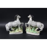 PAIR OF STAFFORDSHIRE ZEBRAS, later 19th century, with a front leg raised, height 22cm (2)