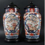 PAIR OF JAPANESE IMARI VASES, late 19th century, with landscape cartouches, later hardwood covers