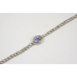 A SAPPHIRE AND DIAMOND BRACELET the oval-shaped sapphire is set within a surround millegrain set