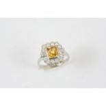 A YELLOW SAPPHIRE AND DIAMOND CLUSTER RING the yellow sapphire is set within a surround of two