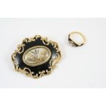 A GOLD AND BLACK ENAMEL MOURNING BROOCH the black enamel mount centred with a locket compartment