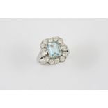 AN AQUAMARINE AND DIAMOND CLUSTER RING the step-cut aquamarine is set within a surround of two